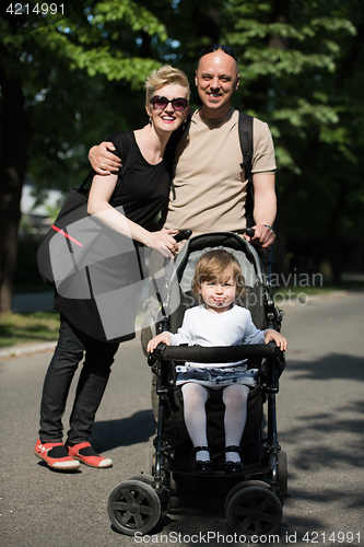 Image of couple with baby pram in summer park