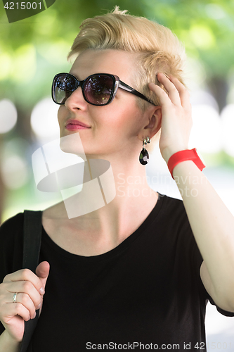 Image of young woman with short blond hair and sunglasses