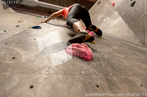 Image of foot of woman exercising at indoor climbing gym