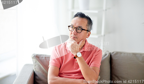Image of asian man thinking at home