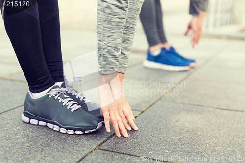 Image of close up of couple stretching on city street