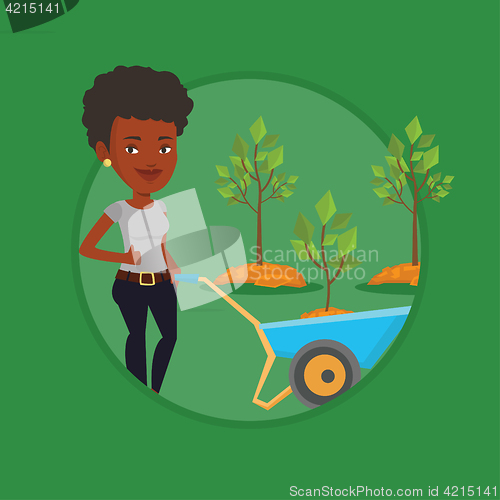 Image of Woman pushing wheelbarrow with plant.