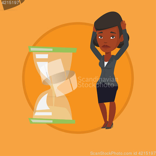 Image of Desperate business woman looking at hourglass.