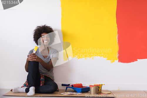 Image of back female painter sitting on floor