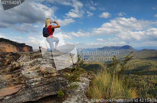 Image of Woman drinking water on mountain summit Australia