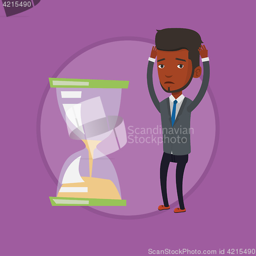 Image of Desperate businessman looking at hourglass.