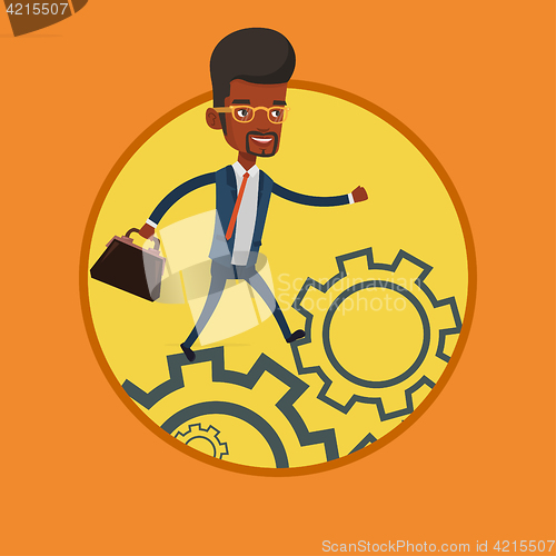 Image of Business man running on cogwheels.