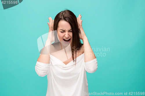 Image of Frustrated young woman posing on blue