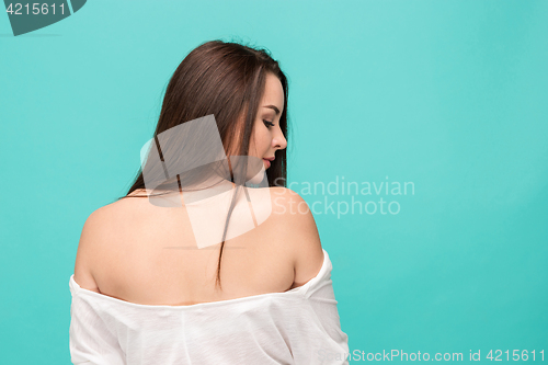 Image of The back of young woman posing on blue