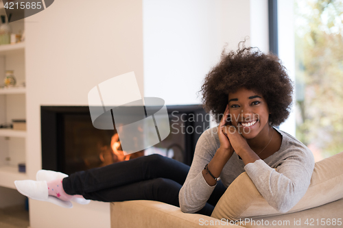 Image of black woman in front of fireplace