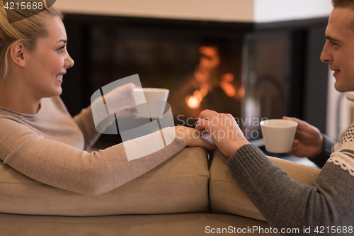 Image of Young couple  in front of fireplace