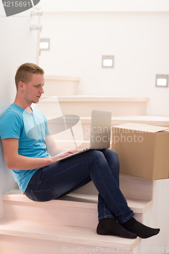 Image of young man sitting in stairway at home