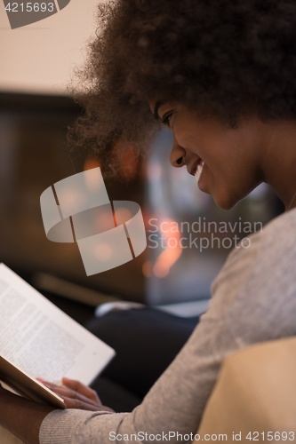 Image of black woman at home reading book