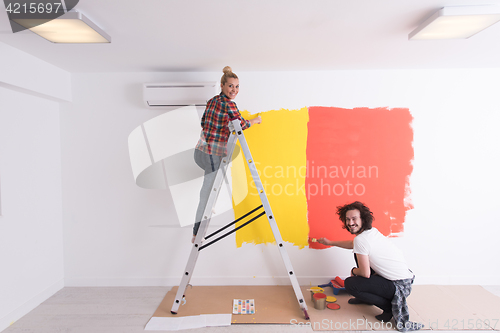 Image of couple painting interior wall