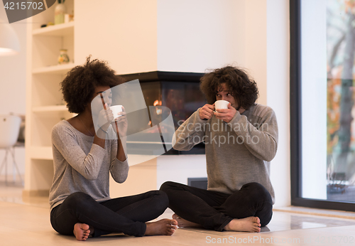 Image of multiethnic couple  in front of fireplace