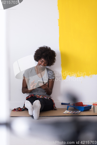 Image of back female painter sitting on floor