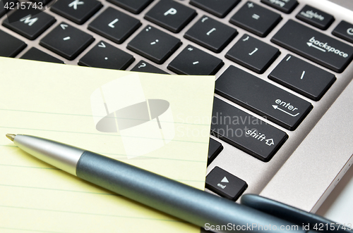 Image of Notepad and pen on black keyboard