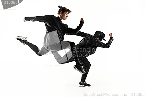 Image of The silhouettes of two hip hop male and female break dancers dancing on white background