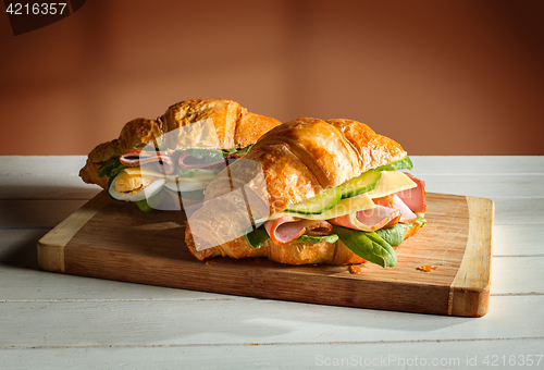 Image of Croissants sandwiches on the wooden cutting board