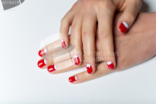 Image of Female hands with red and white nails