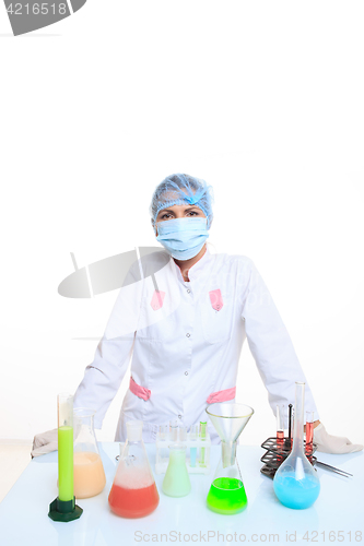 Image of Woman chemist and chemicals in flasks