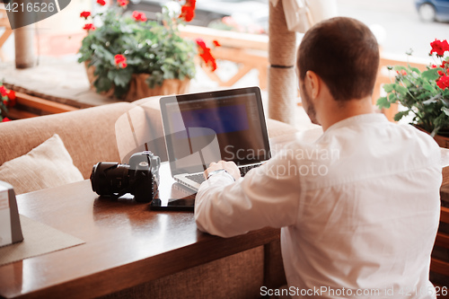 Image of Man is looking at laptop with excitement.