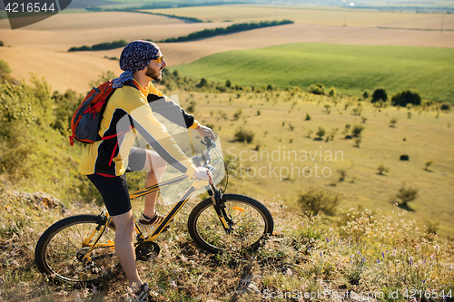 Image of young bright man on mountain bike