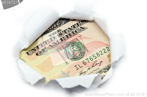 Image of US currency peeking through white paper.