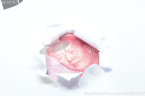 Image of China currency through torn white paper