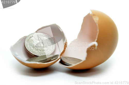 Image of Cracked egg shell and coins