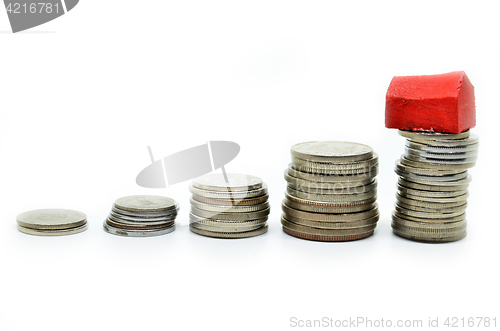 Image of Coins stacked up in piles with color house