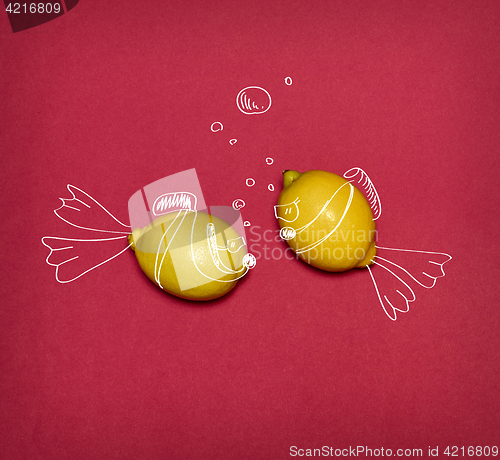 Image of The pop art collage of fresh lemons and drawing fishes on red background