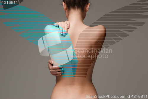 Image of The back of attractive woman with angel wings on gray