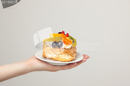 Image of Closeup of cake with fresh fruits on gray background.