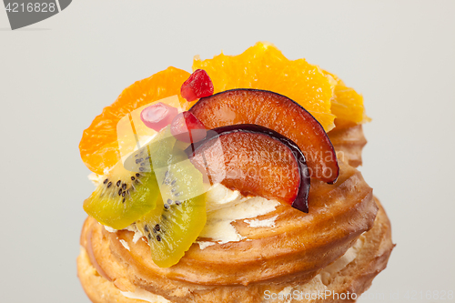 Image of Closeup of cake with fresh fruits on gray background.