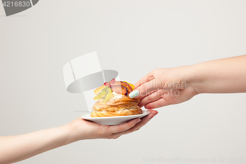 Image of Closeup of cake with fresh fruits on gray background.