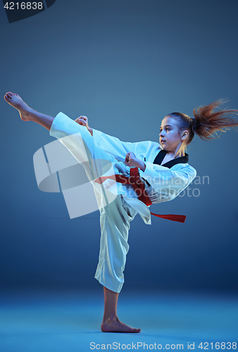 Image of Young girl training karate on blue background