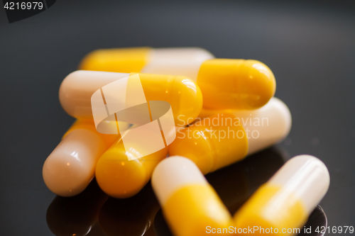 Image of Yellow-white capsules with medicine, close-up