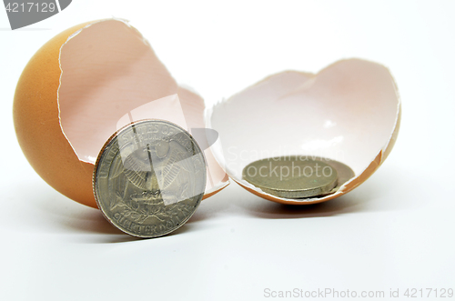 Image of Cracked egg shell and coins