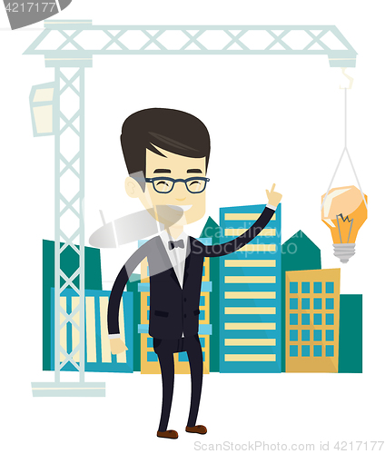 Image of Man pointing at idea bulb hanging on crane.