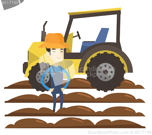 Image of Farmer standing with tractor on background.