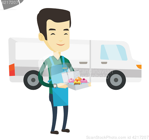 Image of Delivery man holding a box of cakes.