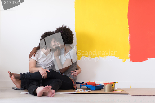 Image of young multiethnic couple relaxing after painting
