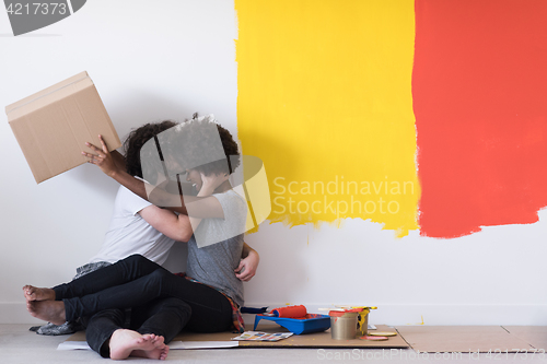 Image of young multiethnic couple playing with cardboard boxes