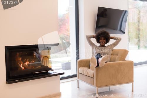 Image of black woman in front of fireplace