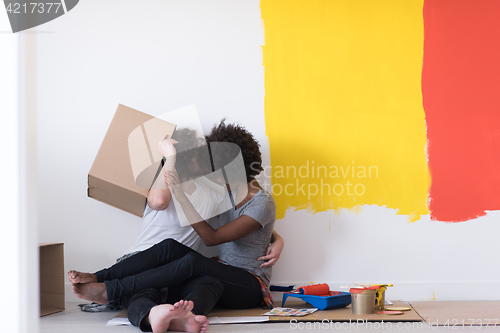 Image of young multiethnic couple playing with cardboard boxes