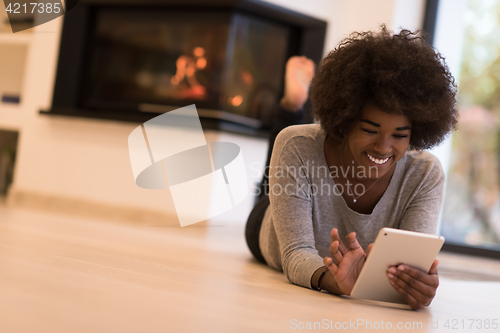 Image of black women using tablet computer on the floor