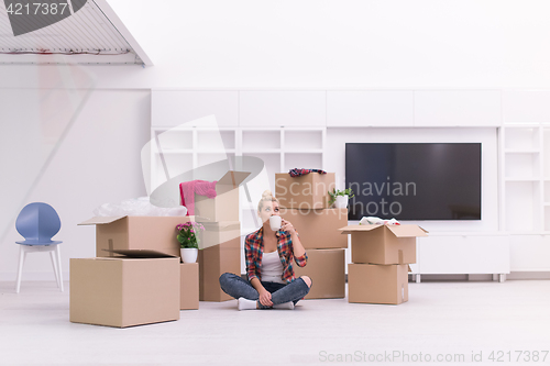 Image of woman with many cardboard boxes sitting on floor