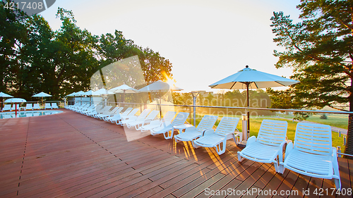 Image of Relaxing chairs beside swimming pool