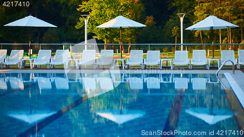 Image of Relaxing chairs beside swimming pool